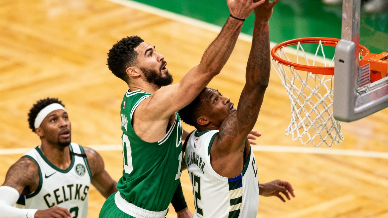 NBA季后赛凯尔特人对阵雄鹿的直播画面，绿色与白色球衣的球员在篮下卡位争抢篮板